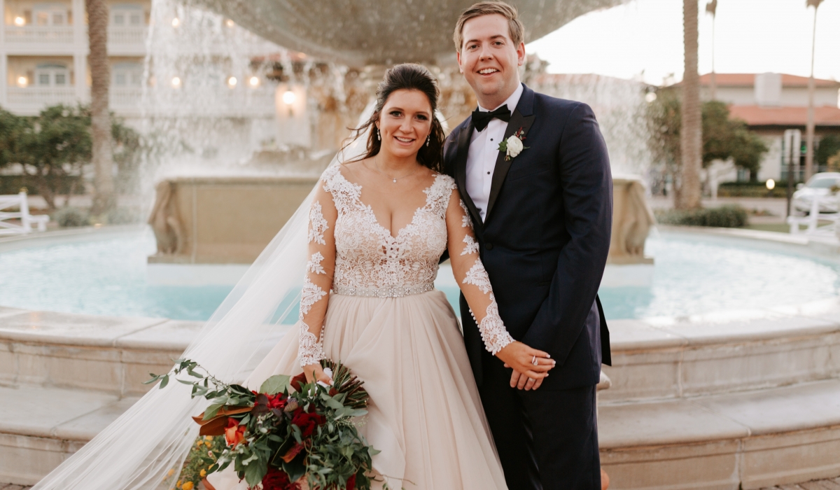 A bride and groom smile in front of the iconic fountain at Ponte Vedra Inn & Club.