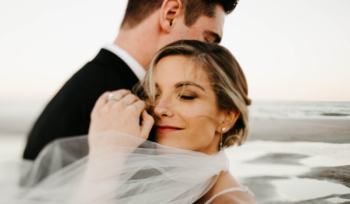A bride smiles as she embraces her groom at Ponte Vedra Inn & Club.